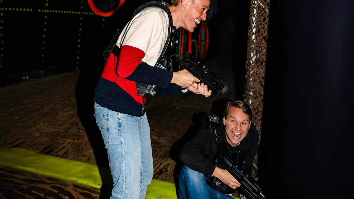 Two people playing laser tag in an indoor arena in Rotterdam.
