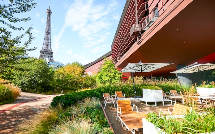 Outdoor seating area at Musee du Quai Branly with Eiffel Tower in the background, Paris.