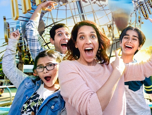 Family taking a selfie in front of the Universal globe at Universal Studios, Los Angeles.