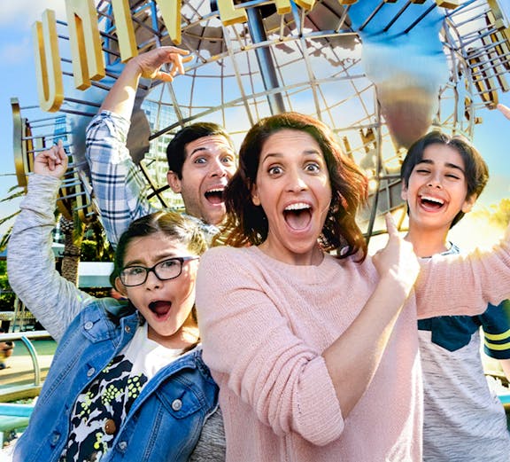 Family taking a selfie in front of the Universal globe at Universal Studios, Los Angeles.