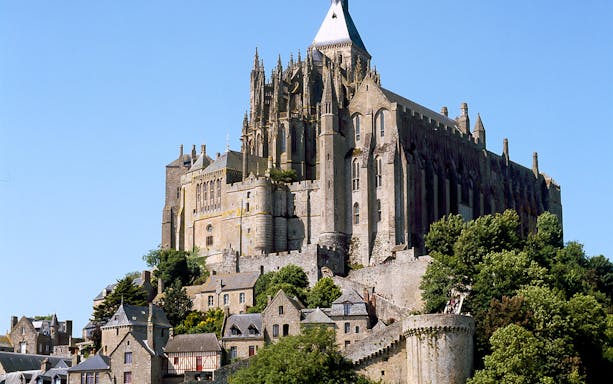 Mont Saint Michel Abbey with surrounding village buildings in Normandy, France.