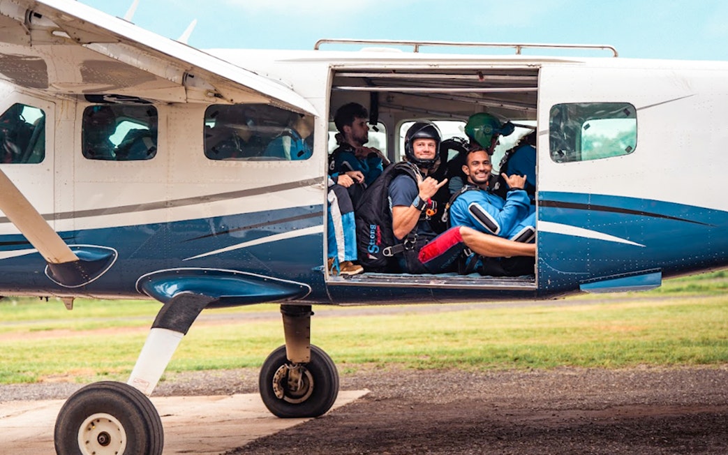 Skydivers in plane preparing for Sydney tandem skydive with city transfers.