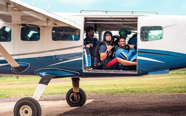 Skydivers in plane preparing for Sydney tandem skydive with city transfers.