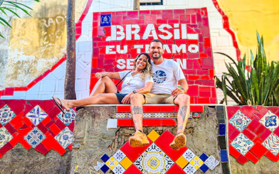 Tourists sitting on colorful Selaron Steps in Rio de Janeiro, Brazil.
