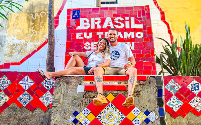 Tourists sitting on colorful Selaron Steps in Rio de Janeiro, Brazil.