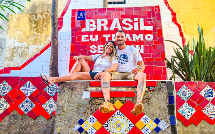 Tourists sitting on colorful Selaron Steps in Rio de Janeiro, Brazil.