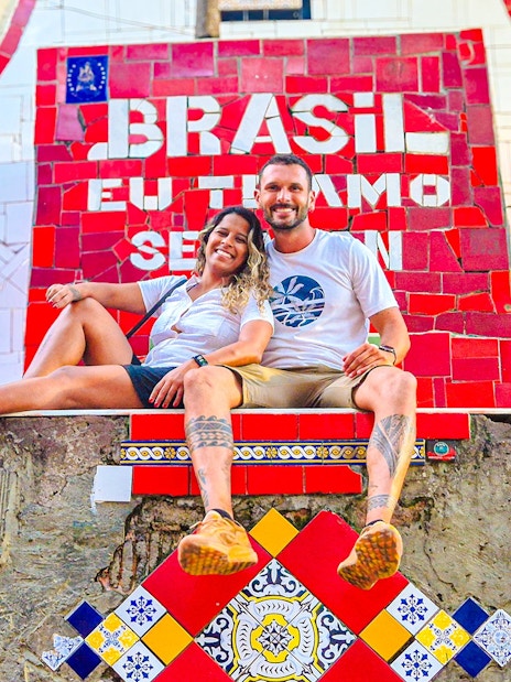 Tourists sitting on colorful Selaron Steps in Rio de Janeiro, Brazil.