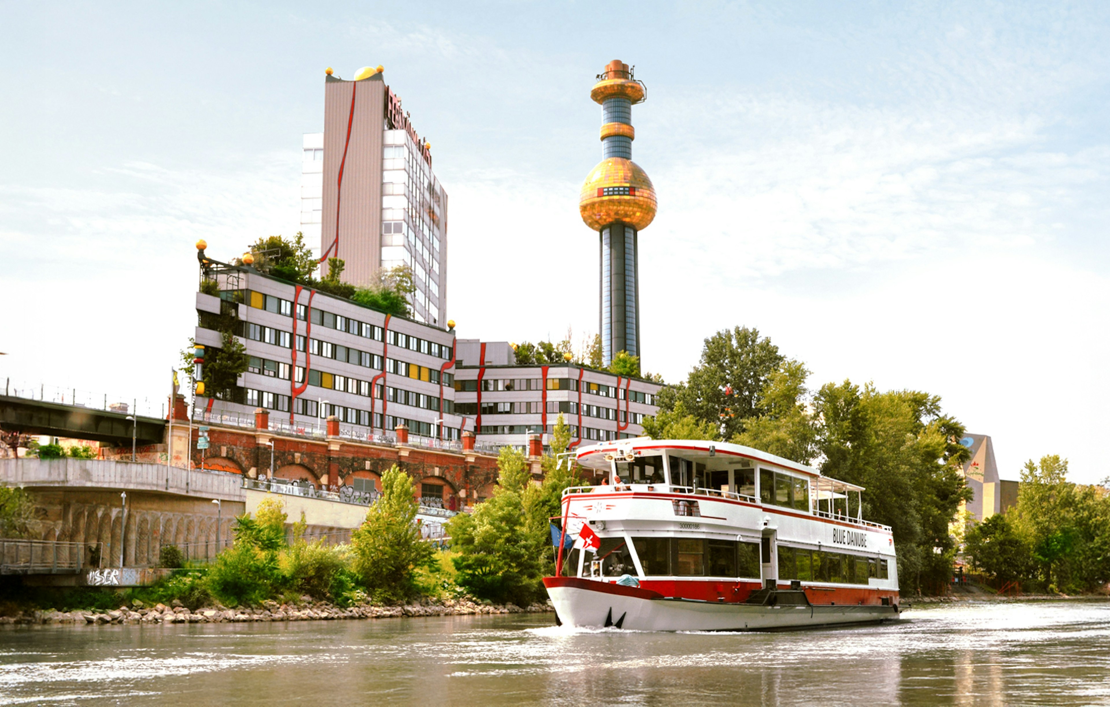 MS Blue Danube cruise on Danube Canal, Vienna, with Spittelau incineration plant in background.