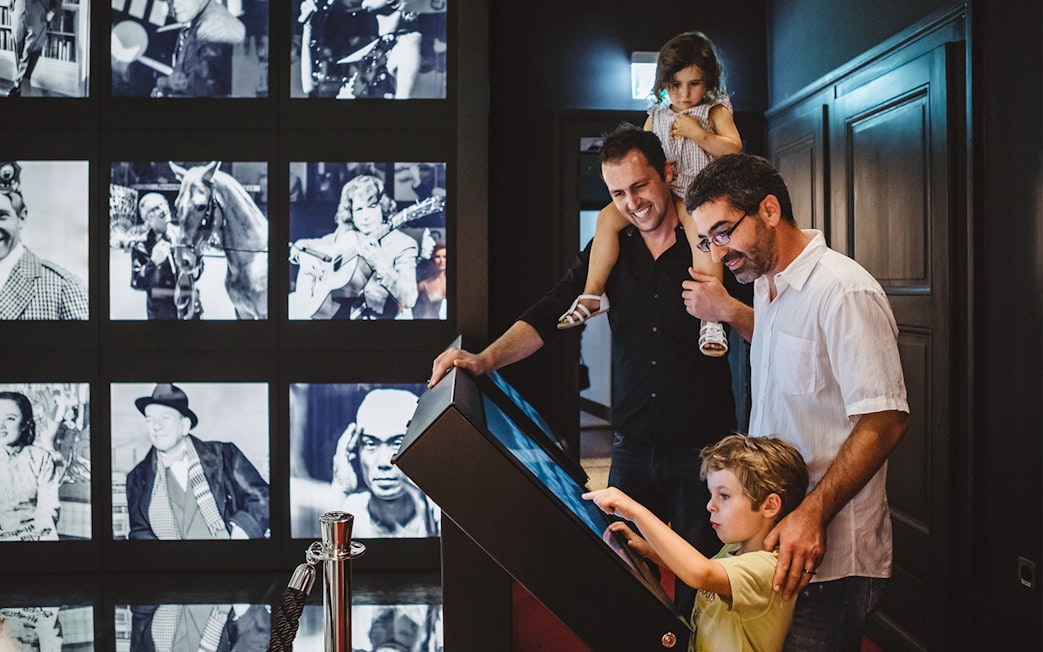 Visitors interacting with an exhibit at Chaplin’s World, Lake Geneva tour.