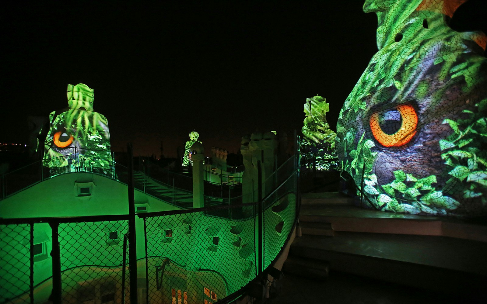 Casa Mila rooftop at night with illuminated sculptures, Barcelona.