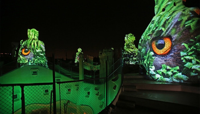 Casa Mila rooftop at night with illuminated sculptures, Barcelona.