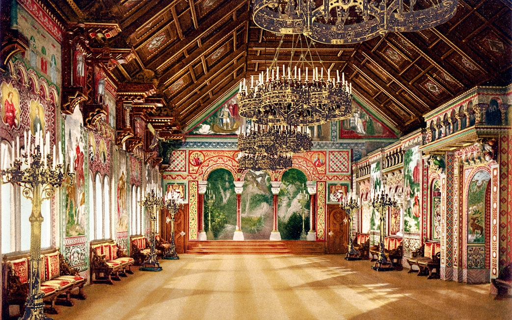Neuschwanstein Castle interior with ornate chandeliers and detailed wall murals.