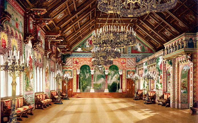 Neuschwanstein Castle interior with ornate chandeliers and detailed wall murals.