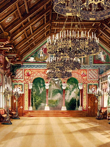 Neuschwanstein Castle interior with ornate chandeliers and detailed wall murals.