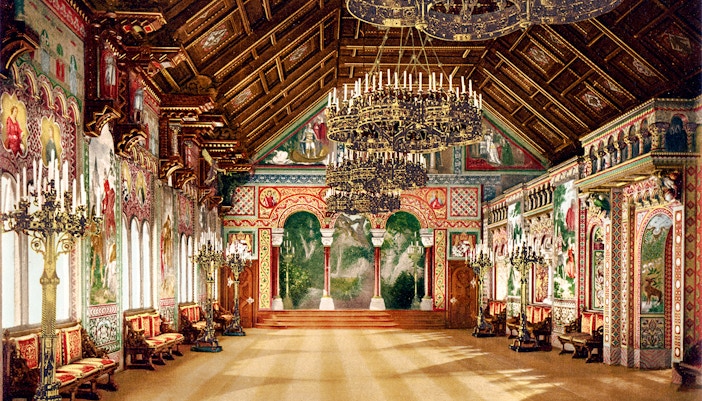 Neuschwanstein Castle interior with ornate chandeliers and detailed wall murals.