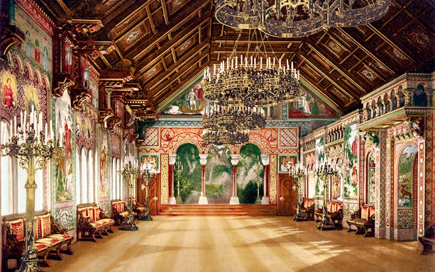Neuschwanstein Castle interior with ornate chandeliers and detailed wall murals.