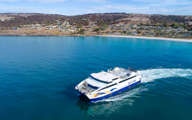 SeaLink ferry traveling from Kangaroo Island with coastal town in the background.