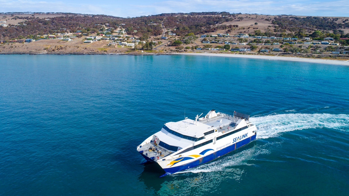 SeaLink ferry traveling from Kangaroo Island with coastal town in the background.