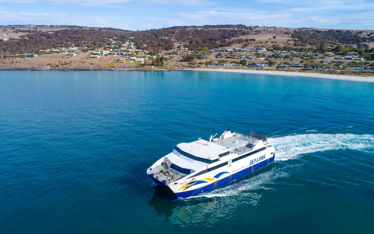 SeaLink ferry traveling from Kangaroo Island with coastal town in the background.