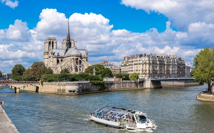 Seine River cruise boat near Notre-Dame Cathedral in Paris.