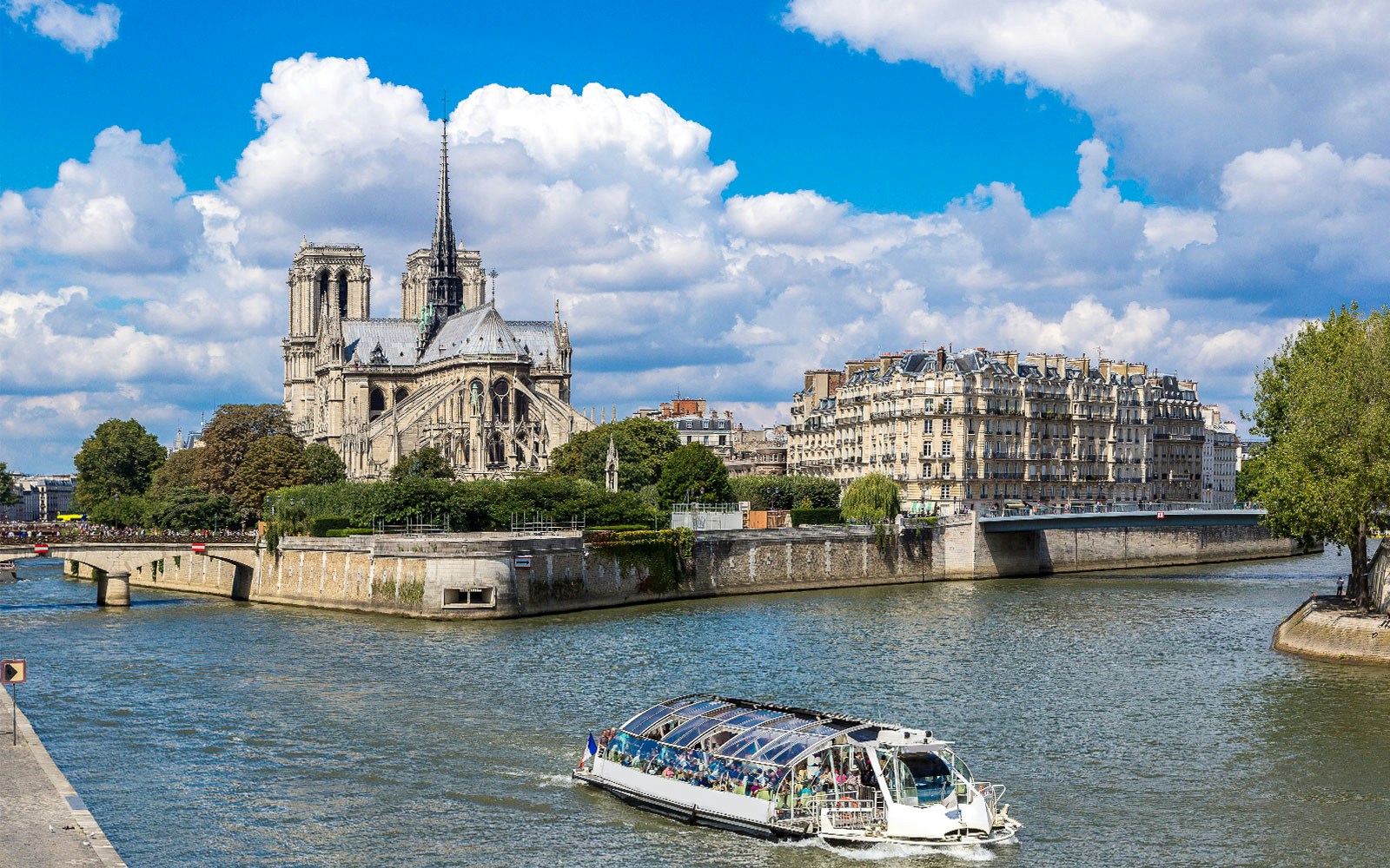Seine River cruise boat near Notre-Dame Cathedral in Paris.