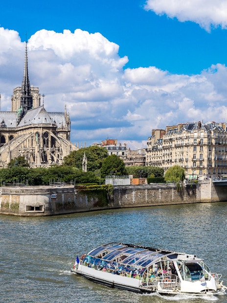 Seine River cruise boat near Notre-Dame Cathedral in Paris.