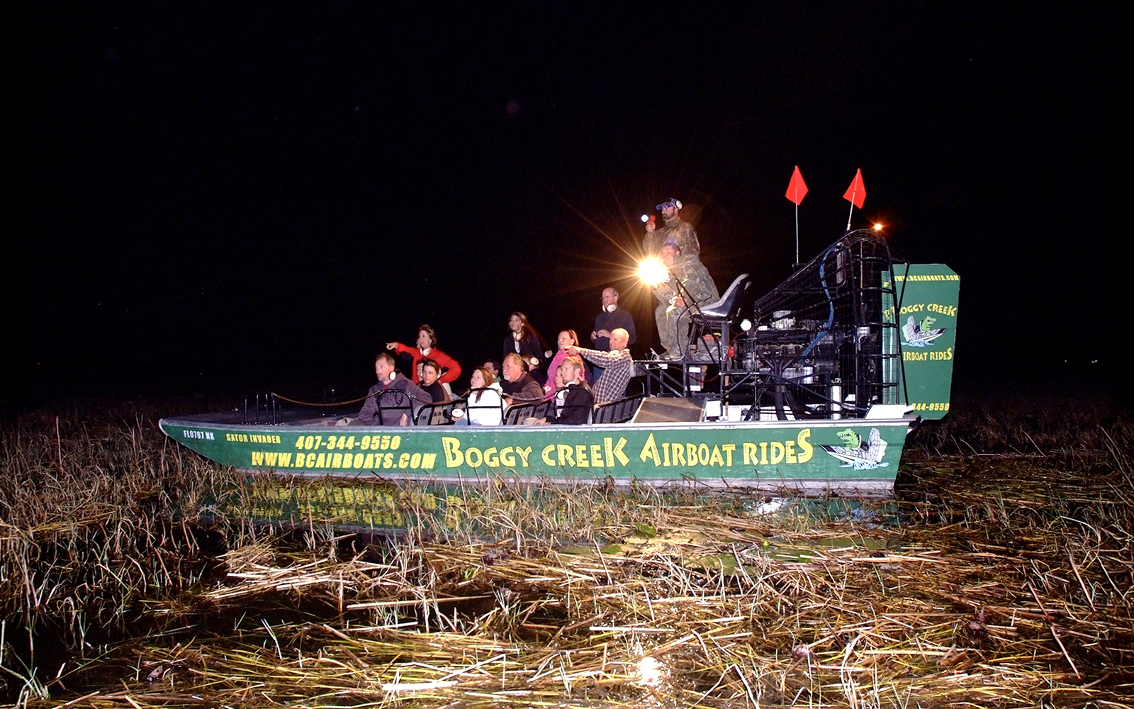 Guests on Boggy Creek night airboat tour in marshland.