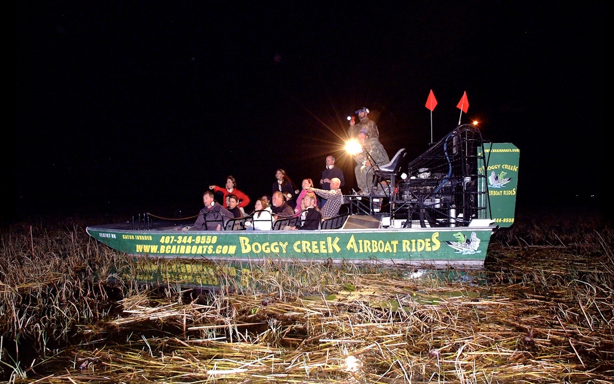 Guests on Boggy Creek night airboat tour in marshland.