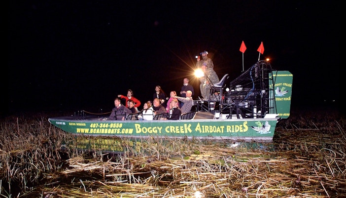 Guests on Boggy Creek night airboat tour in marshland.