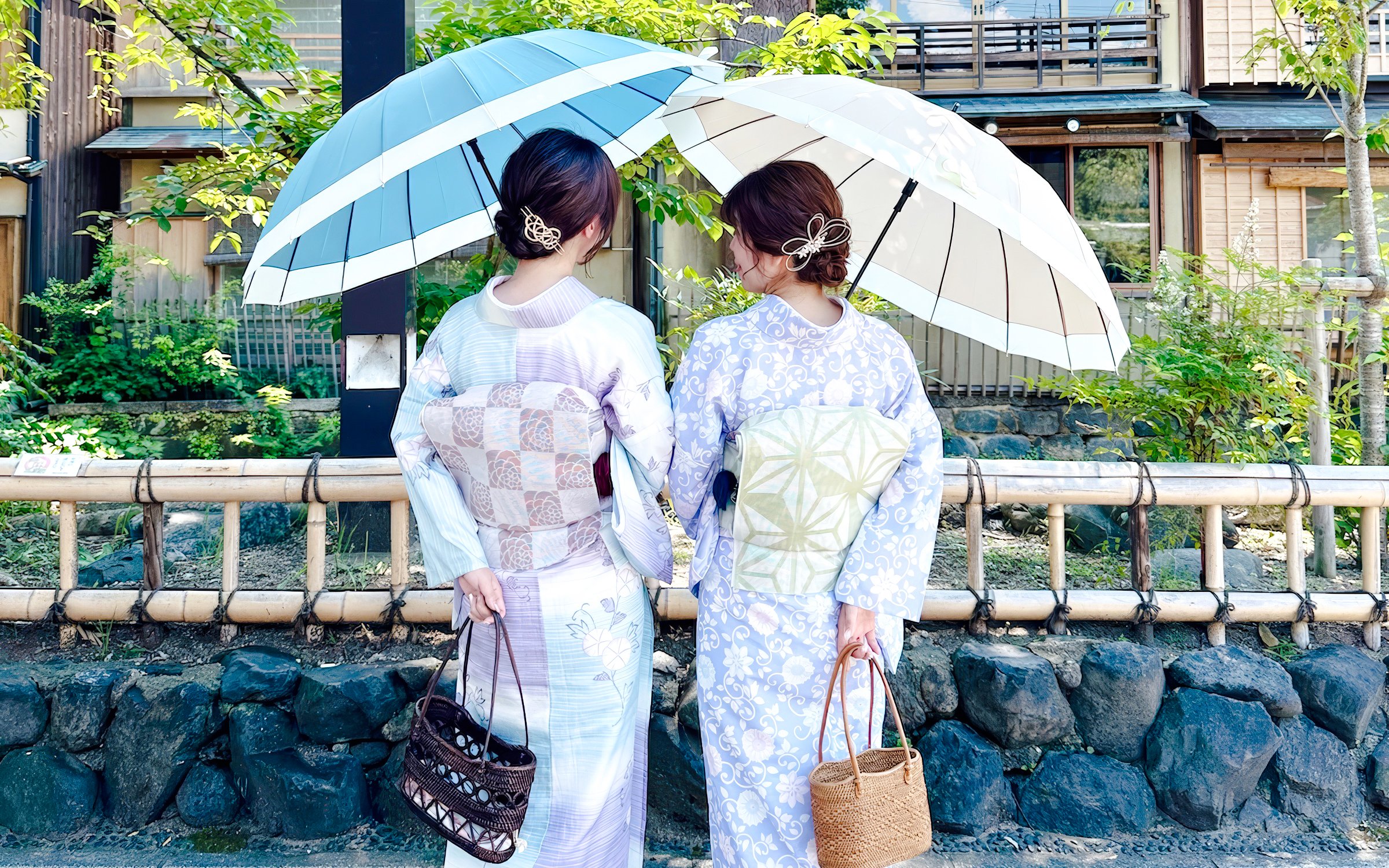 Individuals in kimonos with umbrellas in historic Kyoto district, Japan.