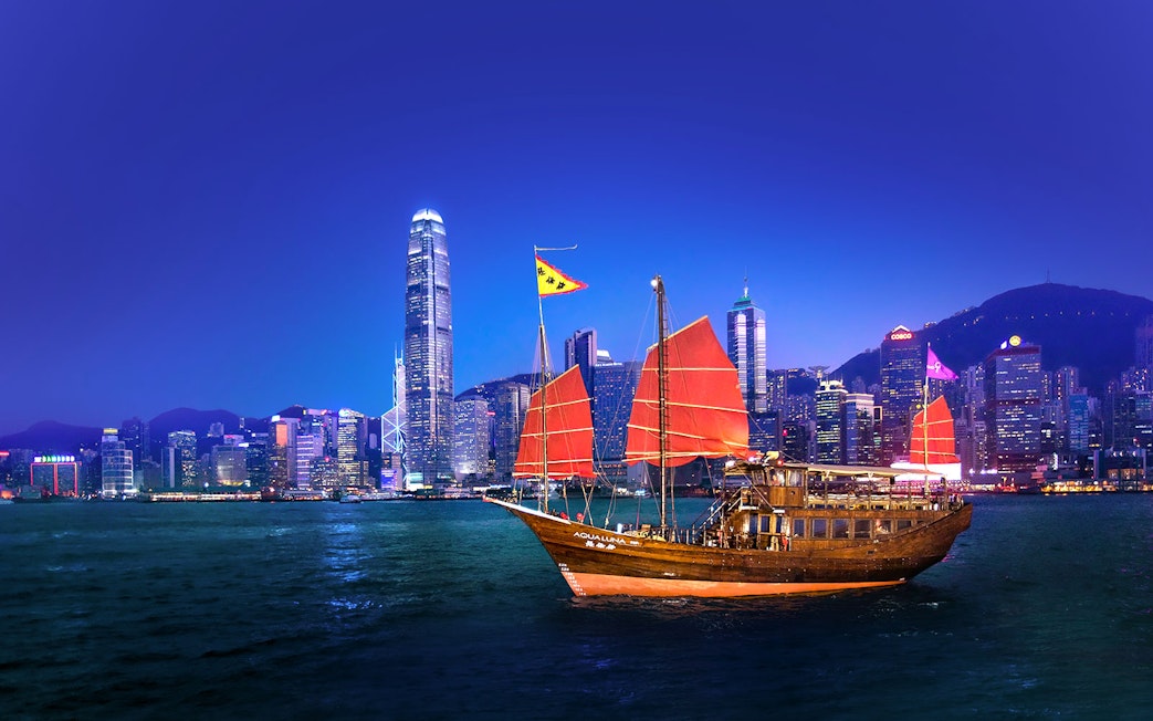 Traditional junk boat with red sails in Hong Kong harbor during AquaLuna day tour.