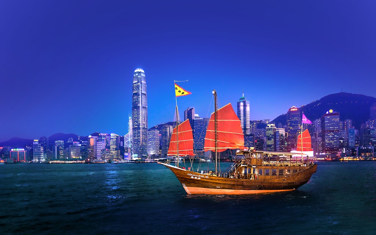 Traditional junk boat with red sails in Hong Kong harbor during AquaLuna day tour.