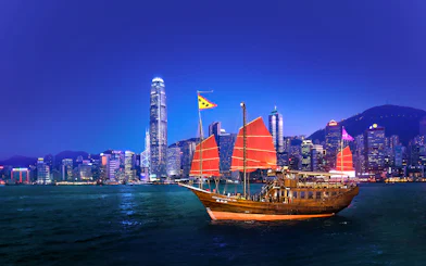 Traditional junk boat with red sails in Hong Kong harbor during AquaLuna day tour.
