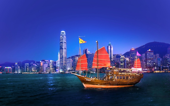 Traditional junk boat with red sails in Hong Kong harbor during AquaLuna day tour.