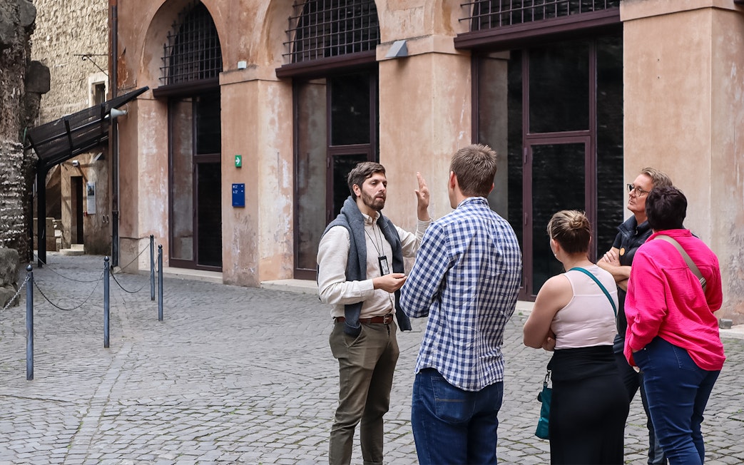 Tour guide explaining history to a group at Castel Sant'Angelo, Rome.