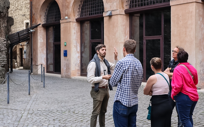 Tour guide explaining history to a group at Castel Sant'Angelo, Rome.