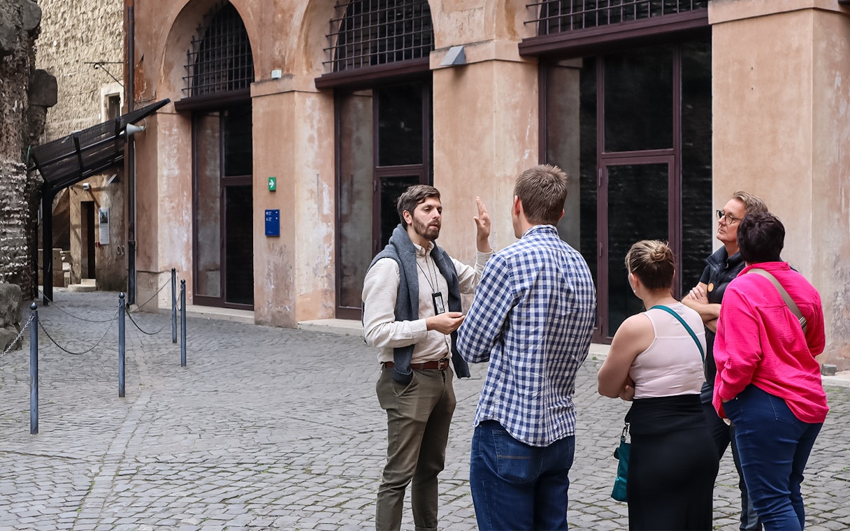 Tour guide explaining history to a group at Castel Sant'Angelo, Rome.