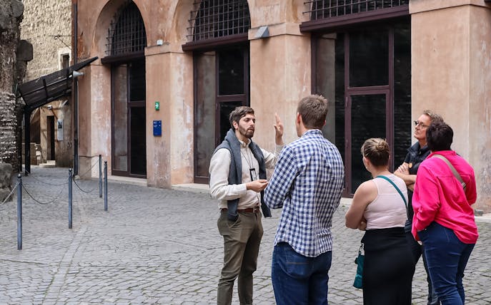 Tour guide explaining history to a group at Castel Sant'Angelo, Rome.