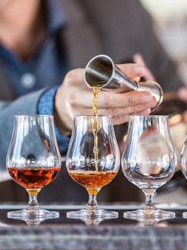 Pouring whiskey into tasting glasses at Middleton Whiskey Distillery.
