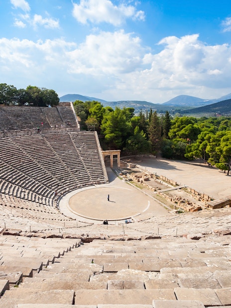 Epidaurus Ancient Theatre in Greece with stone seating and scenic landscape.