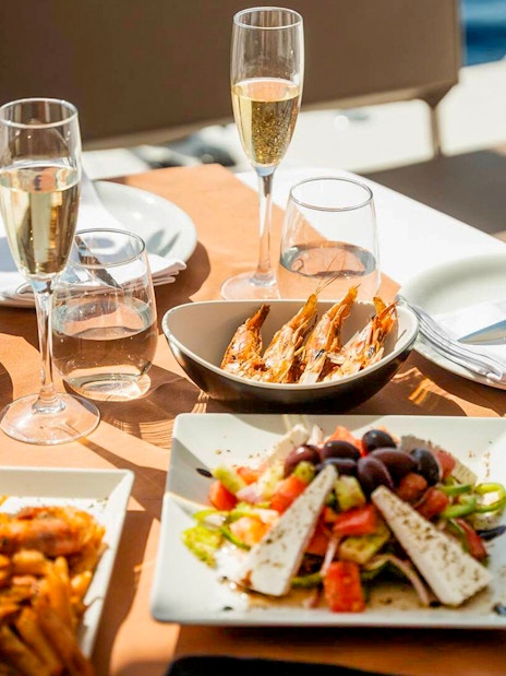 Seafood and salad meal on Santorini luxury catamaran cruise table.