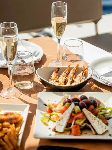 Seafood and salad meal on Santorini luxury catamaran cruise table.