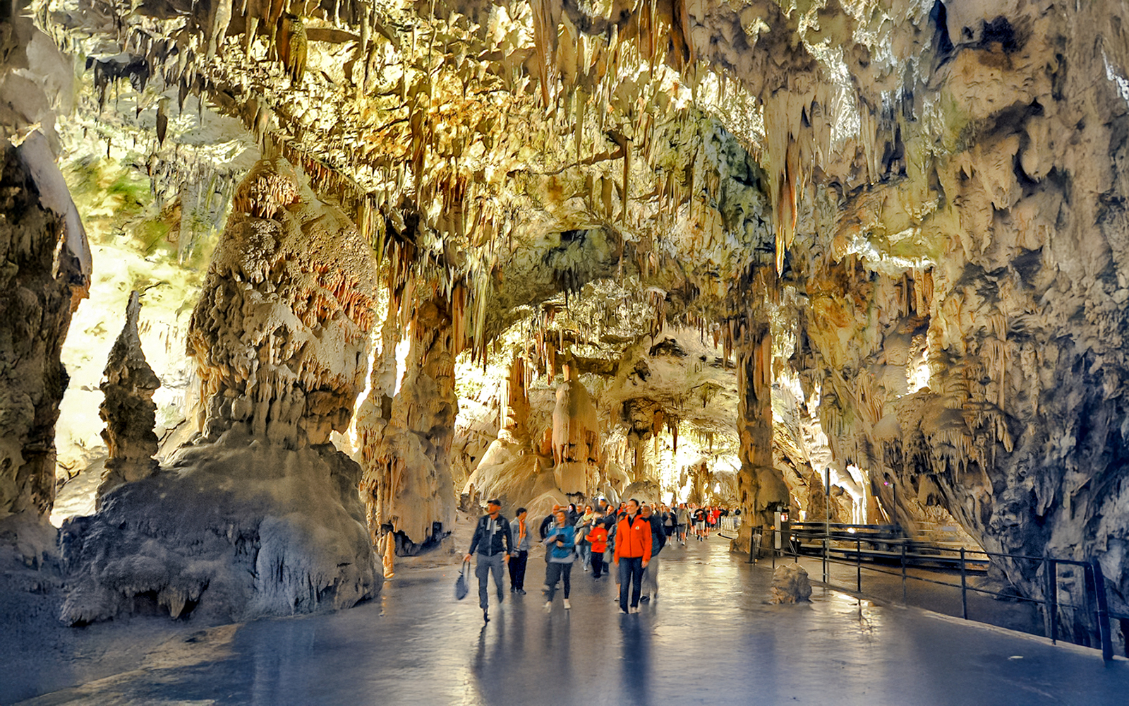 Visitors exploring stalactites and stalagmites inside Postojna Cave, Slovenia.