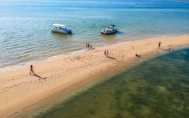 Boat tour visitors enjoying Deserta Island beach in Ria Formosa, Portugal.