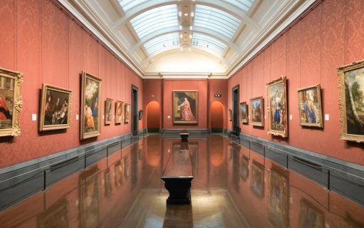 Interior of a gallery room with classic paintings at the National Gallery, London.