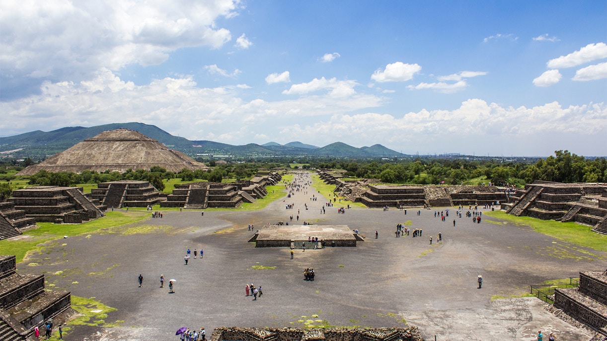 Teotihuacan pyramids with tourists exploring ancient Mesoamerican site near Mexico City.