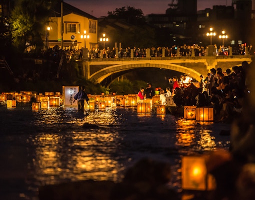 Lanterns floating on Sumida River during festival in Tokyo, Japan.