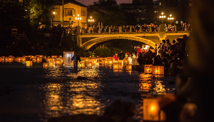 Lanterns floating on Sumida River during festival in Tokyo, Japan.