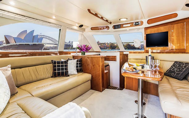 Luxury yacht interior with Sydney Opera House view, part of a whale watching tour.