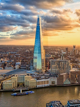 The Shard skyscraper in London at sunset with cityscape and river views.